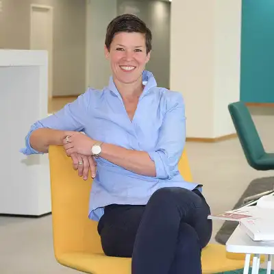 Ruth Schulze von der Robert Bosch GmbH sitzt lächelnd in einem großen Büro mit gelben und grünen Stühlen Ruth Schulze von der Robert Bosch GmbH sitzt lächelnd in einem großen Büro mit gelben und grünen Stühlen