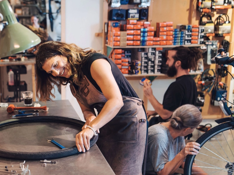 Fahrradmechanikerin arbeitet im Team mit guter Laune